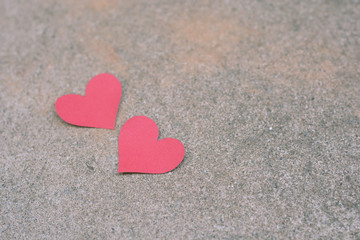 red paper heart shape on concrete background