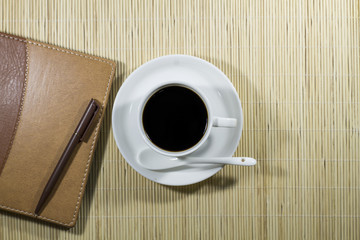 Obraz na płótnie Canvas Hot coffee cup with note book