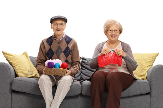 Seniors sitting on a sofa and knitting together