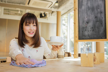 カフェで接客をする若い日本人の女性
