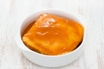 typical dish francesinha on white bowl in white background