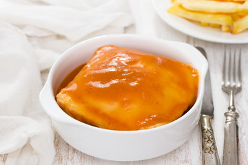 typical dish francesinha on white bowl in white background