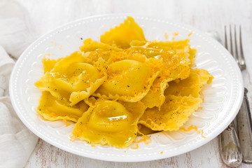 boiled ravioli with cheese on white plate