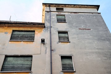 Old and damaged  facade of uninhabited building.