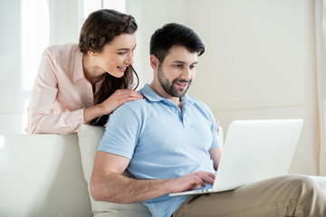 Fototapeta premium portrait of woman looking at man using laptop at home