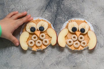 Funny owl with peanut butter and fruits on rice cake