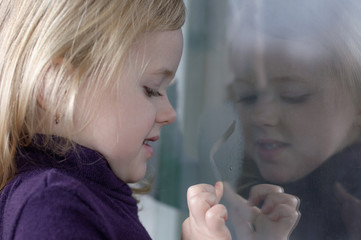 Girl draws on the window
