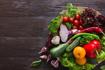 Plenty of fresh vegetables on wooden background with copy space