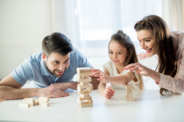 portrait of happy family playing jenga game at home