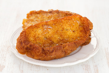 fried sweet bread with cinnamon on plate