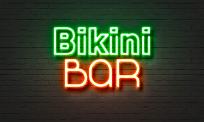 Bikini bar neon sign on brick wall background.