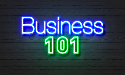 Business 101 neon sign on brick wall background.