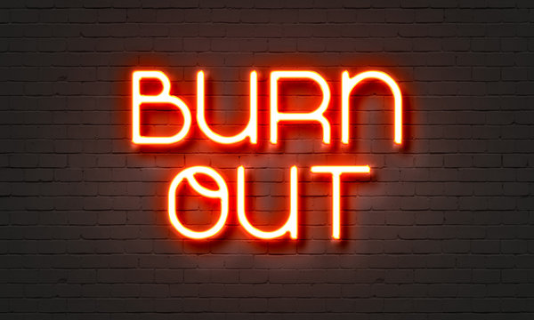 Burnout neon sign on brick wall background.