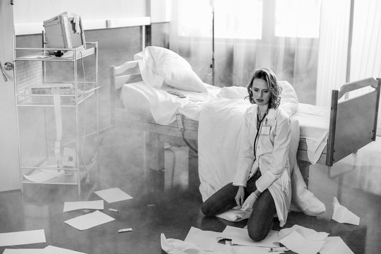 Black And White Photo Of Upset Doctor In Uniform In Ruined Hospital Chamber