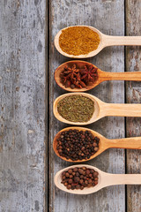 Fragrant spices in wooden spoons.