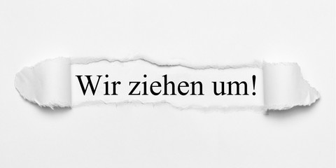 Wir ziehen um! auf weißen gerissenen Papier