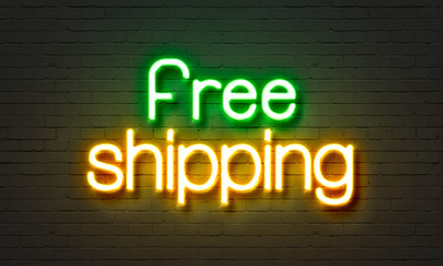 Fototapeta premium Free shipping neon sign on brick wall background.