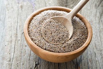 Weiße Chiasamen in Holzschälchen mit Kochlöffel