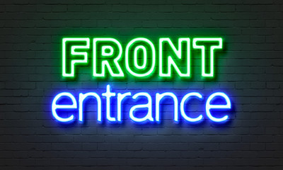Front entrance neon sign on brick wall background.