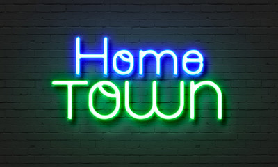 Hometown neon sign on brick wall background.