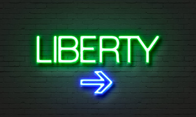 Liberty neon sign on brick wall background.