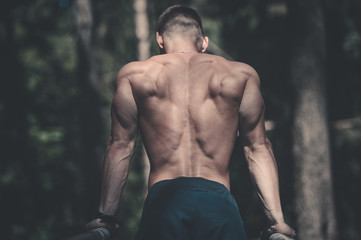 Fototapeta na wymiar man doing exercises in outdoor gym naked torso.