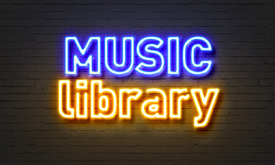 Music library neon sign on brick wall background.