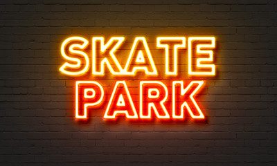 Skate park neon sign on brick wall background.