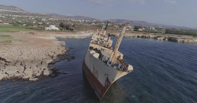 Aerial epic 4k shot of a big, old, broken, rusty boat near the coast of Peyia, Cyprus. Ship graveyard. Famous landmark in the Mediterranean sea.