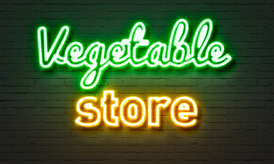 Vegetable store neon sign on brick wall background.