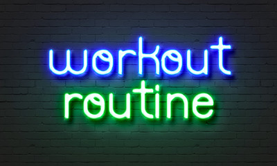 Workout routine neon sign on brick wall background.
