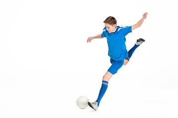 Young boy with soccer ball doing flying kick