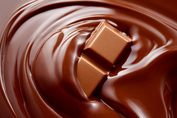 Chocolate background. Chocolate bar in hot melted chocolate.