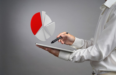 Man in white shirt working with pie chart on a tablet computer, application for budget planning or...