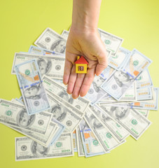 Woman hands with little house and dollars on background. top view. copy space