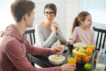 Young female talking to her son by breakfast