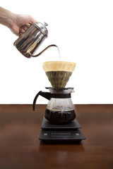 Drip brewing, filtered coffee, or pour-over is a method which involves pouring water over roasted, ground coffee beans contained in a filter isolated on white background