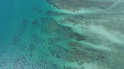 Aerial top view photo of rocky sea shore and water surface with boat