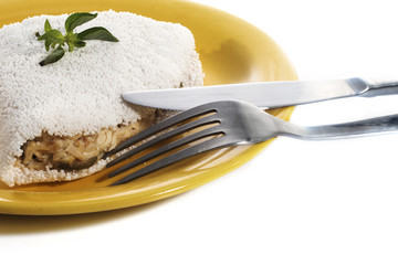 Delicious Tapioca, a brazilian snack made with cassava flour and stuffed with chicken and zucchini on a yellow plate isolated on white background