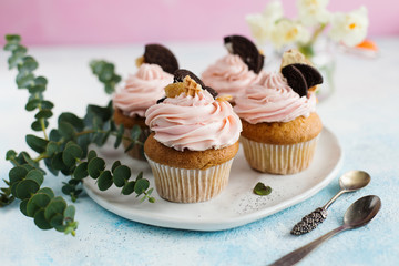 Vanilla cupcakes, decorated with flowers on a pink background