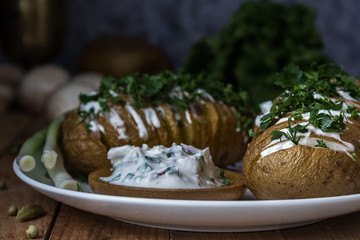 Baked potato on a plate with sauce. Still life. Rustic, moonlight, magical light, low key