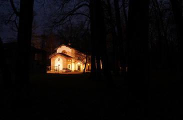 Notturno con casa illuminata nella foresta