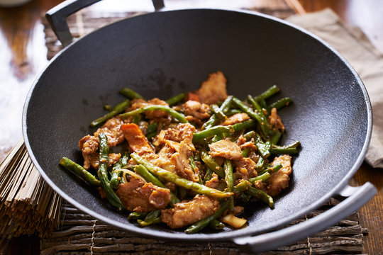 cooked string bean chicken inside large asian wok