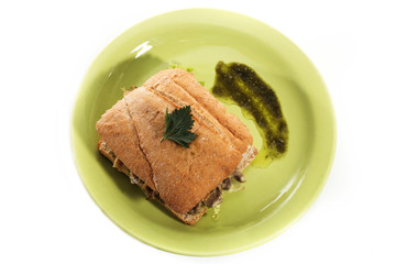 Healthy chicken and mushroom sandwich on green plate over white background