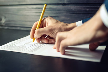 Man lawyer or official signs documents with a pen