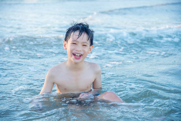 Young asian boy playing on the beach