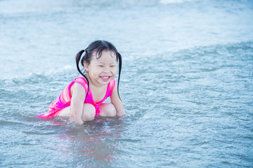 Fototapeta na wymiar Little asian girl smiling in the sea