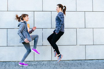 Obraz premium Two sporty women face to face exercising for marathon and workout fitness.