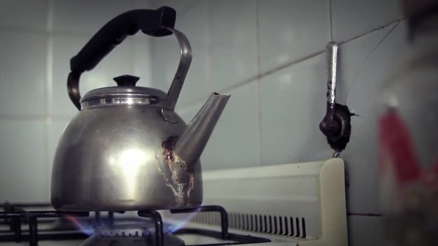 Heating Water In Old Teapot Inside an Old Fashioned Kitchen. Close Up.