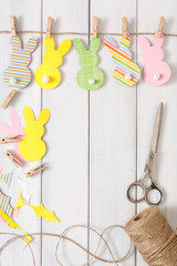 Garland with easter bunnies on white wood background, copy space